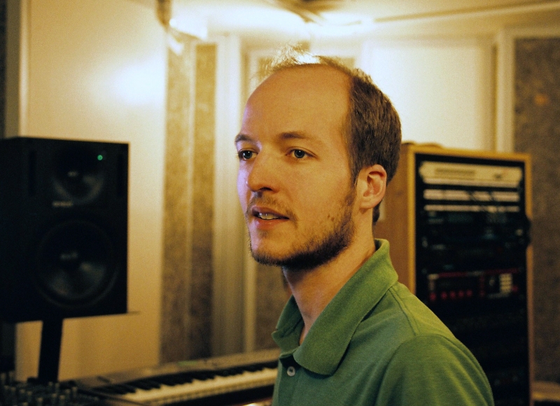 A white man wearing a grene polo shirt in a recording studio