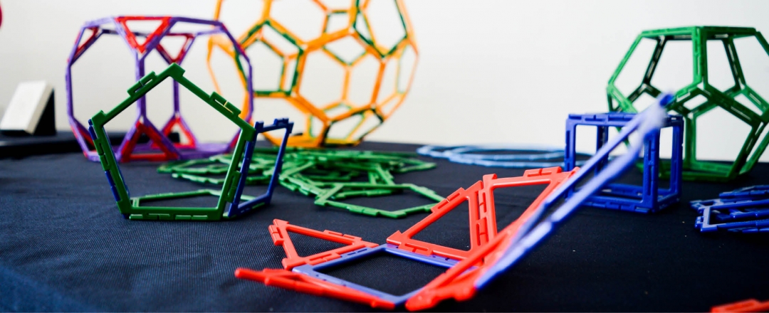 A group of colourful geometric shape toys on a dark blue table